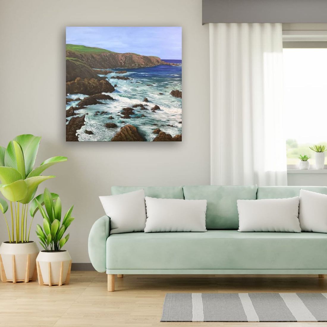 A canvas print of a seascape compliments the cool colour of the furniture